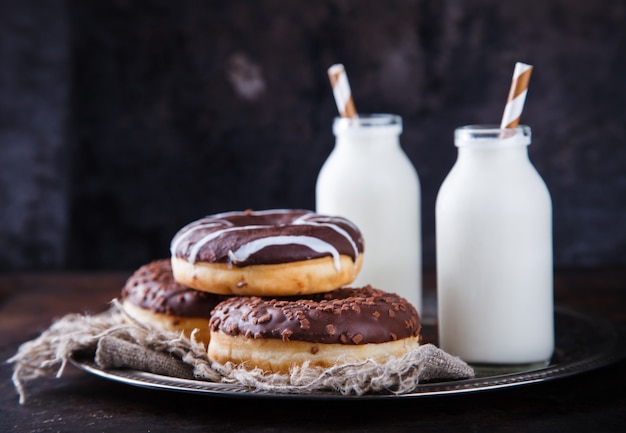 Chocolate donuts with milk on a dark background