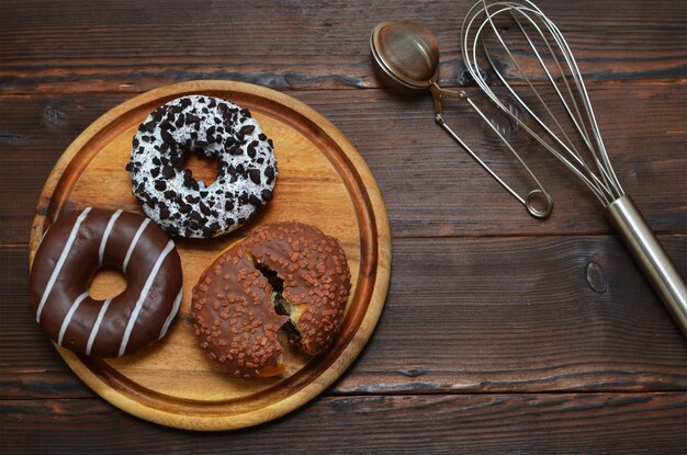 Chocolate donuts on a wooden board flat lay