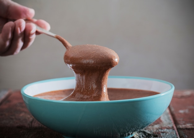 Chocolate dough in plate on old wooden table