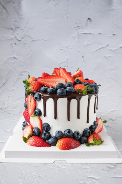 Chocolate drip cake with fresh strawberries and Blueberries