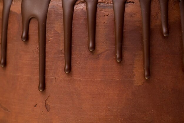 ダークチョコレートガナッシュの背景にチョコレートが滴る