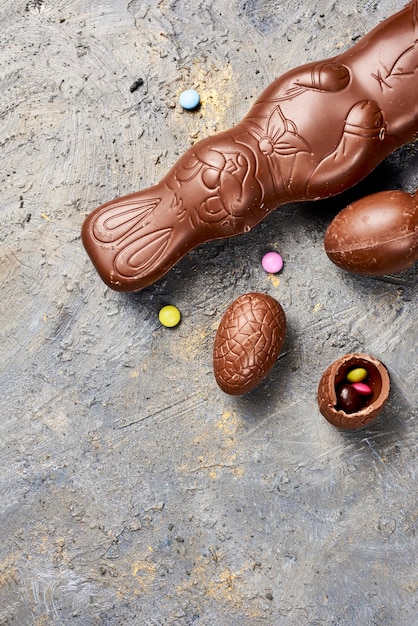 Chocolate Easter bunny eggs and sweets on rustic background