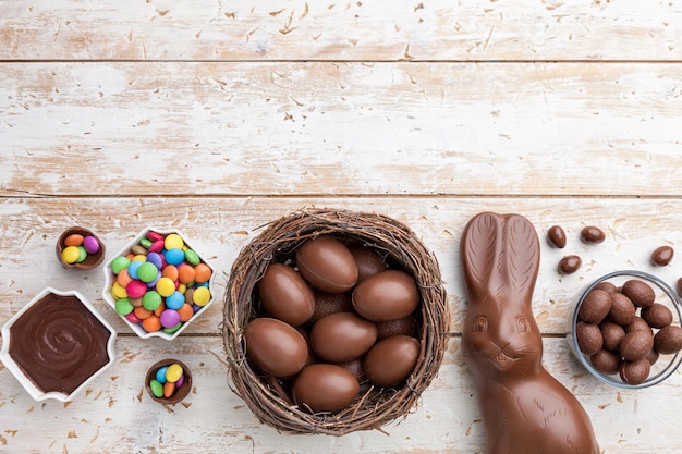 Chocolate Easter bunny eggs and sweets on rustic background