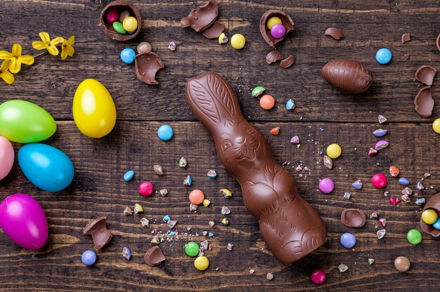 Фото Шоколадные пасхальные яйца и сладости на деревянный стол
