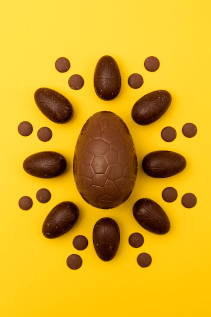 Uova di pasqua al cioccolato su sfondo giallo brillante concetto di vacanza di pasqua