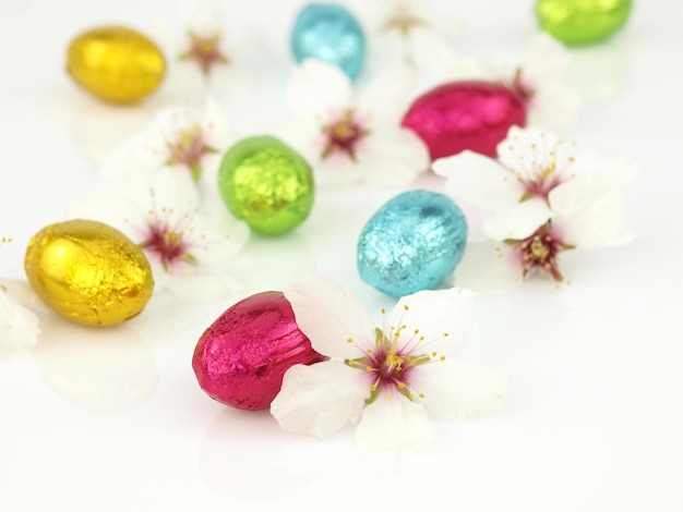 Foto uova di pasqua al cioccolato con fiori primaverili