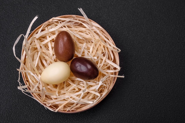 Chocolate Easter hen and eggs in a nest with straw