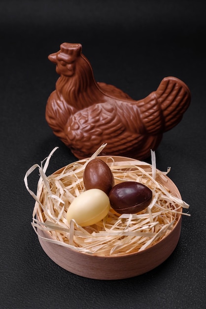 Chocolate Easter hen and eggs in a nest with straw