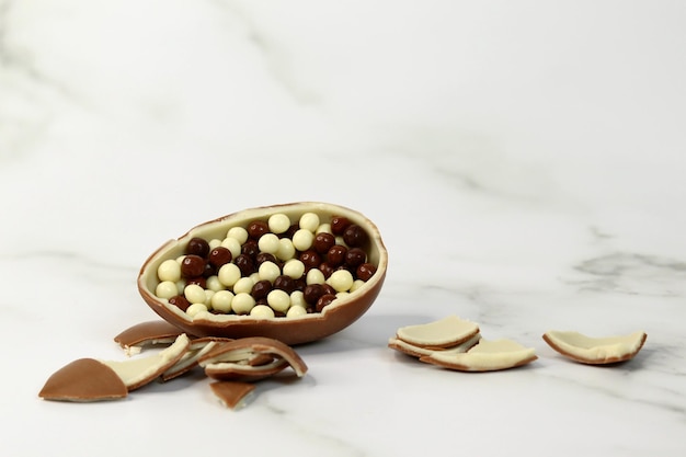 chocolate egg broken into pieces on a light background