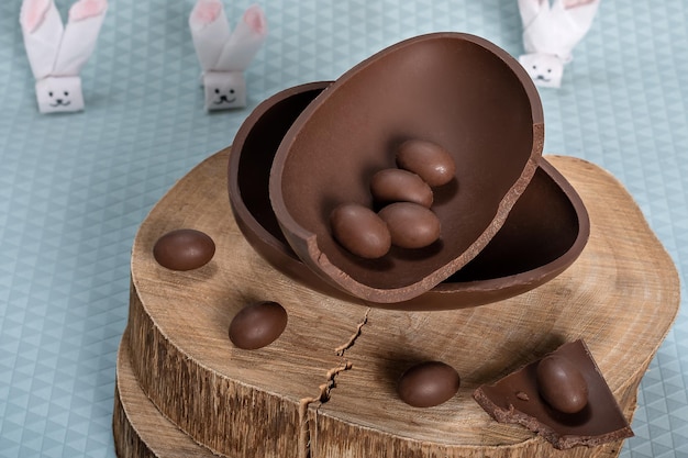 Chocolate egg on a rustic wooden board small chocolate eggs in one half of the chocolate egg easter