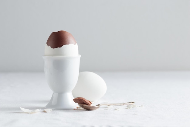 Шоколадное яйцо на белой подставке для яиц