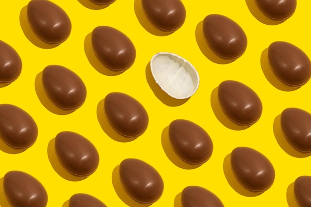 Foto uova di cioccolato modello senza cuciture di uova di cioccolato intere su sfondo giallo