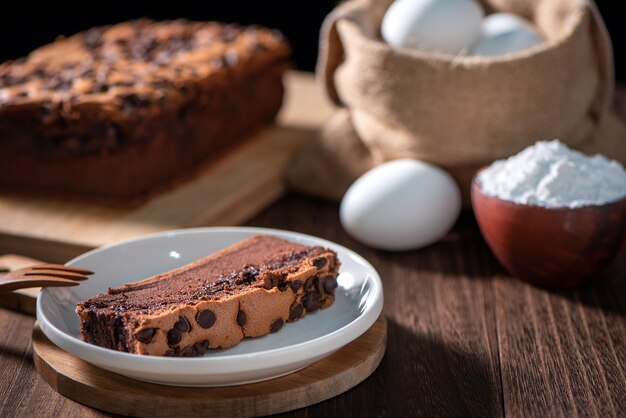 Photo chocolate flavor taiwanese traditional sponge cake taiwanese castella kasutera on a wooden tray background table with ingredients close up