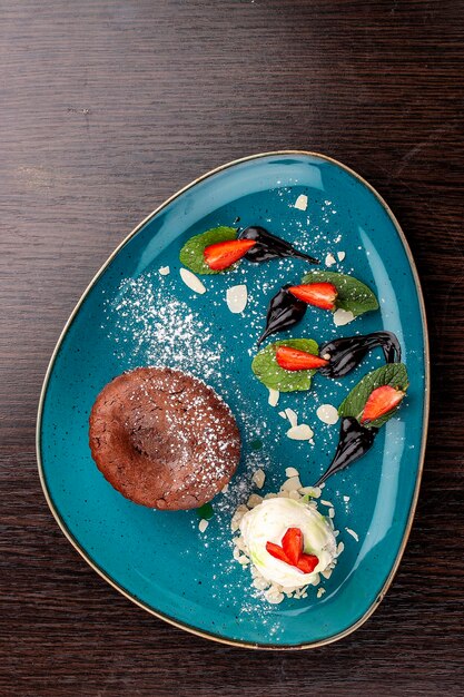 Chocolate fondant with ice cream balls On a wooden background