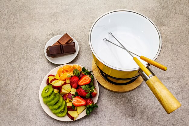Chocolate fondue. Assorted fresh fruits, two types of chocolate. Ingredients for cooking a sweet romantic dessert.