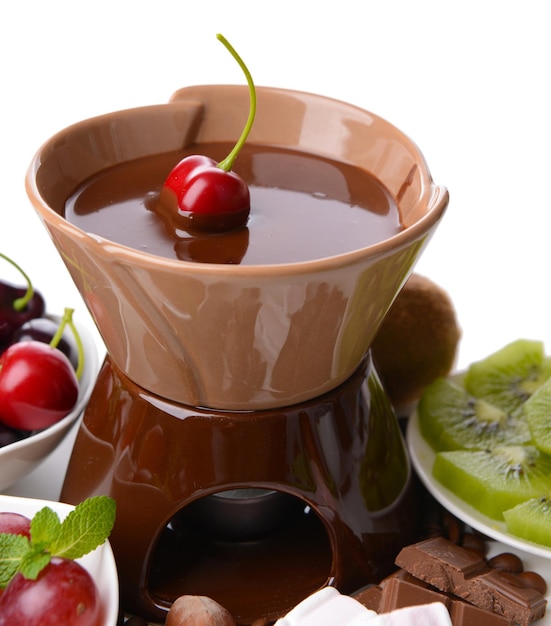 Chocolate fondue with sliced fruits isolated on white