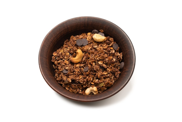 Chocolate granola cereal with nuts in a bowl background. Isolated on white bacckground.