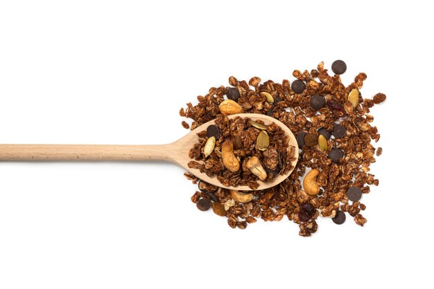 Chocolate granola cereal with nuts in a wooden spoon. Isolated on white bacckground.