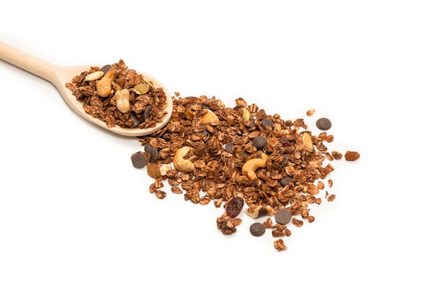 Chocolate granola cereal with nuts in a wooden spoon. Isolated on white.