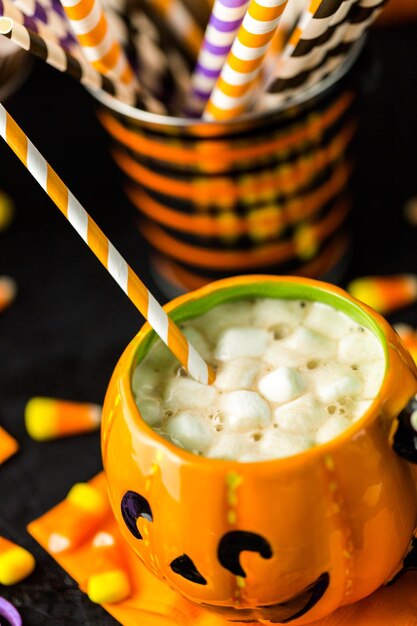 白いバタークリームのアイシングとチョコレートの削りくずが上にあるチョコレートハロウィーンのカップケーキ。