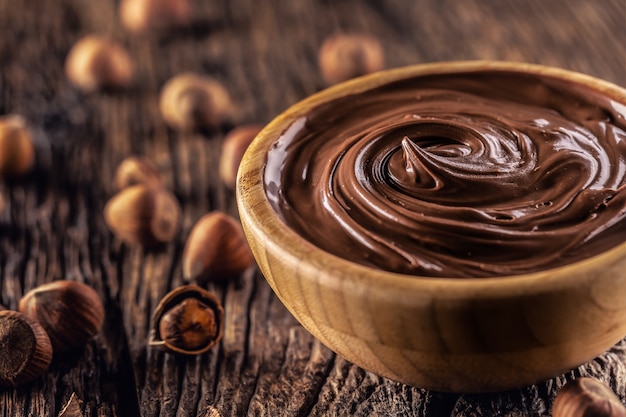 Crema di nocciole al cioccolato in ciotola di legno