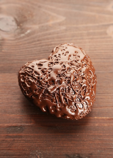 Chocolate heart on a wooden table, close up