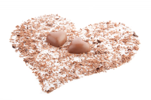 Chocolate hearts and chips on a white.