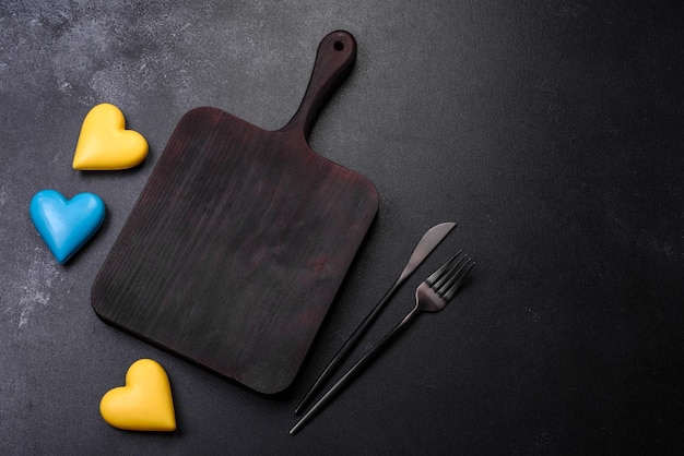 Chocolate hearts in the colors of the Ukrainian flag on a black ceramic plate