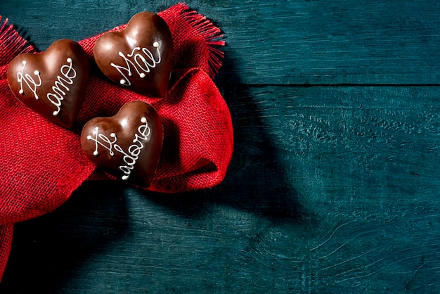 Chocolate hearts with writing in Portuguese  mommy i love you mae te amo copy space top view