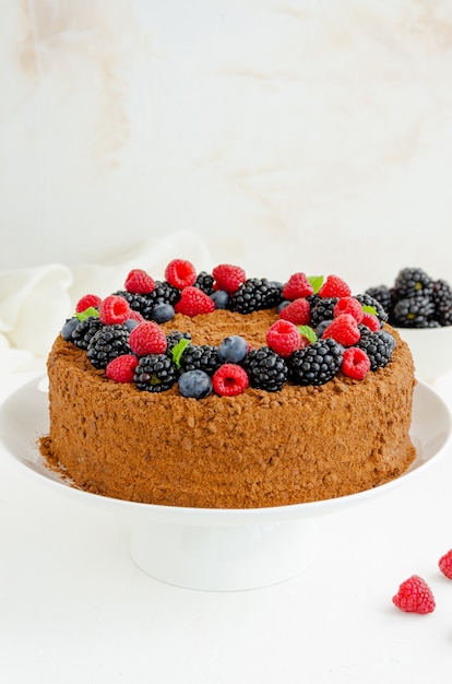 Chocolate honey cake with cream and fresh berries on top