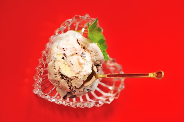 Chocolate ice cream in bowl over red background