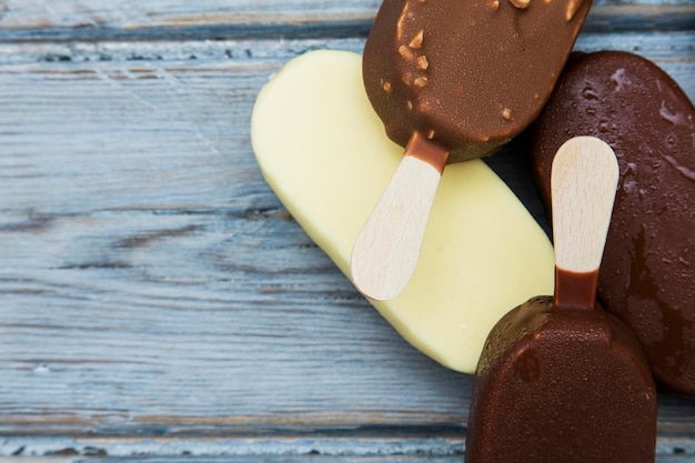 Шоколадные леденцы с мороженым на деревянном фоне