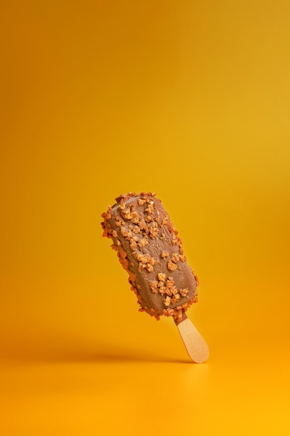 Chocolate ice cream popsicle on yellow