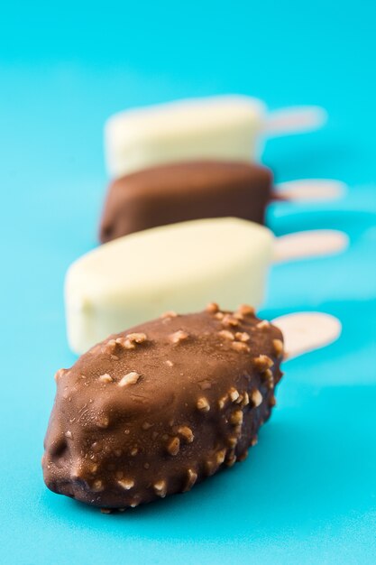 Chocolate ice cream popsicles isolated on blue.