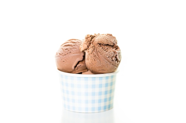 Chocolate ice cream scoops in paper cup.