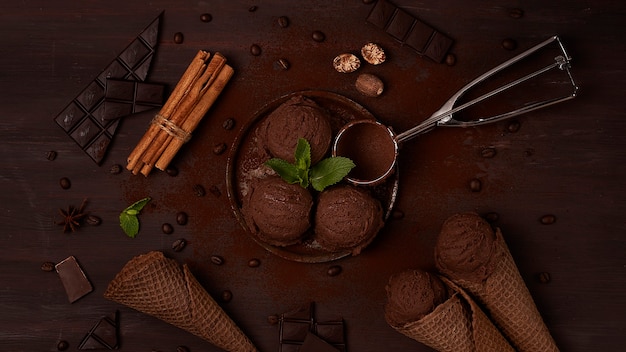 Foto gelato al cioccolato in un cono di cioccolato waffle su uno sfondo marrone concetto vista dall'alto no people