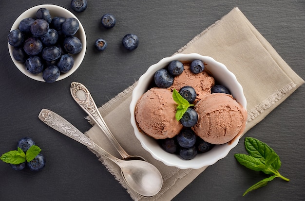 Gelato al cioccolato con mirtilli su sfondo nero ardesia vista dall'alto