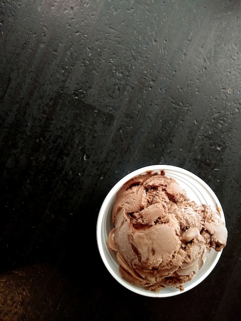 黒の背景とカップのチョコレートアイスクリーム