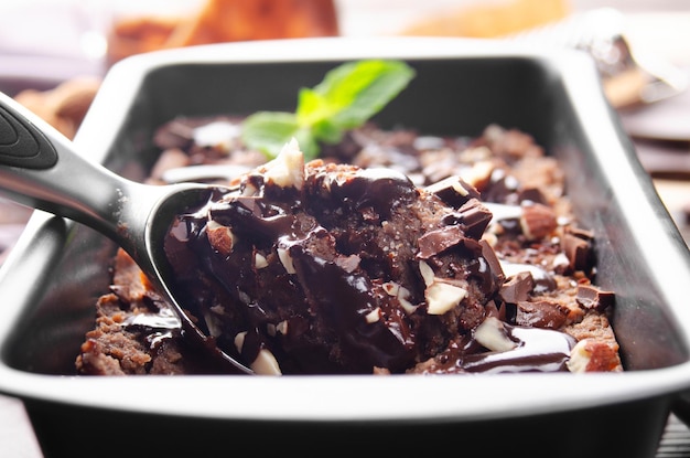 Chocolate icecream in metal tray with mint leaf and almond nuts