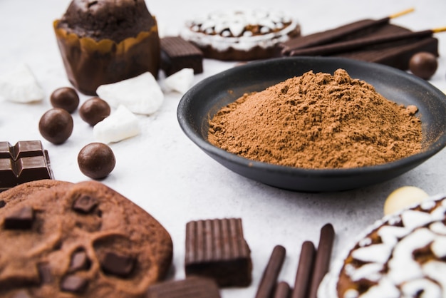 Photo chocolate items with cocoa powder in bowl