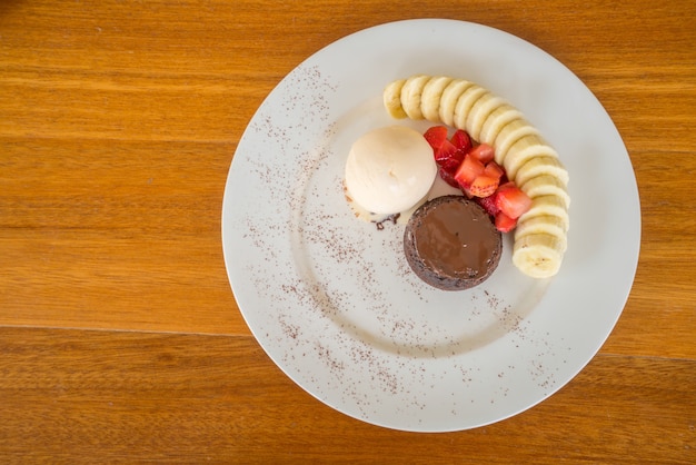 Chocolate lava cake with vanilla icecream, strawberry and banana topping