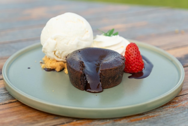 Chocolate lava with vanilla ice-cream and whipping cream on\
plate