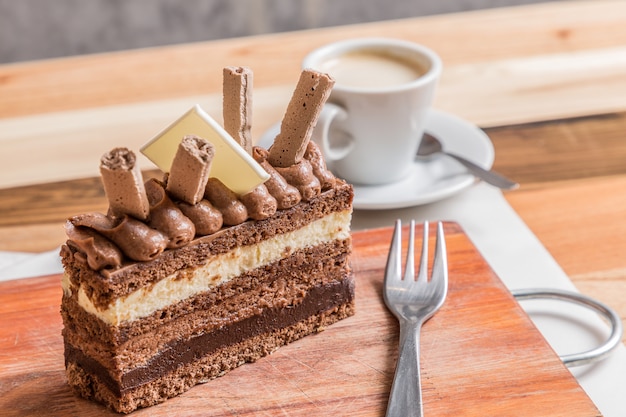 chocolate layer cake on wooden table whit coffee