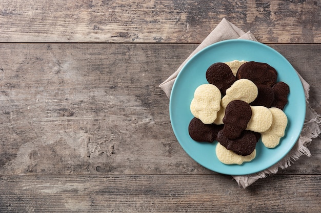 Chocolate Mexican skulls in plate on wooden table