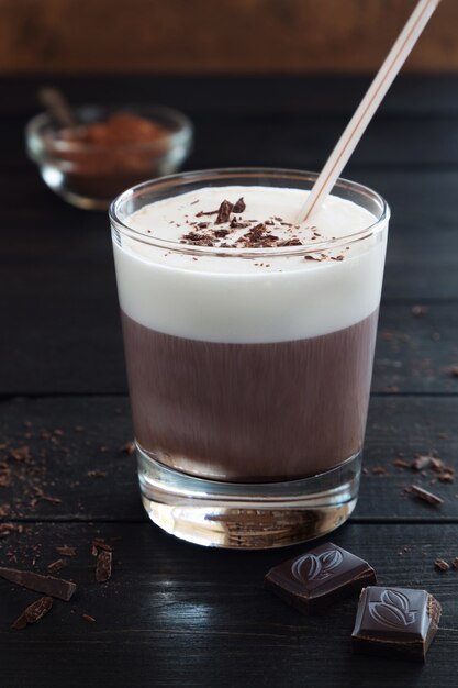 Chocolate milk shake and chocolate crumbs on black wooden background