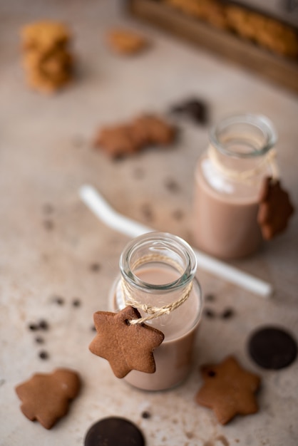 Milkshake al cioccolato in bottiglia di vetro con biscotti friabili di pan di zenzero sul tavolo