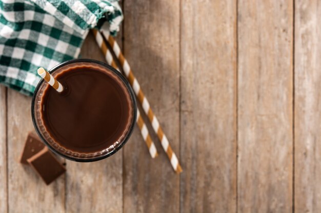 Chocolate milkshake in glass on wooden table