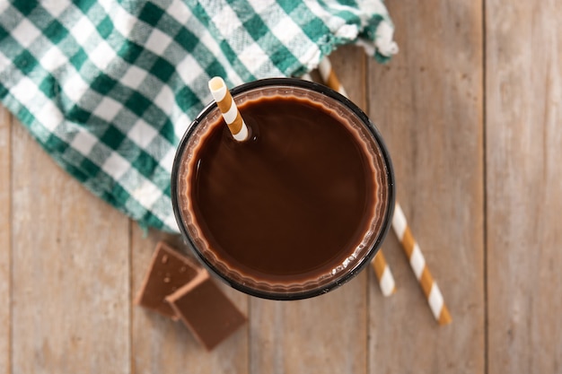 Chocolate milkshake in glass on wooden table