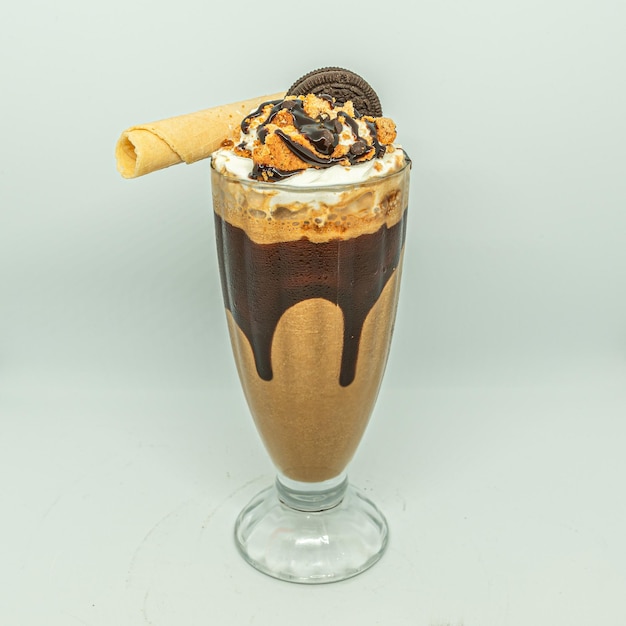 Chocolate milkshake with oreo cookie in a glass cup.