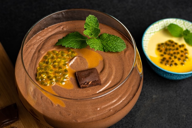 CHOCOLATE MOUSSE IN A GLASS BOWL ON A DARK TABLE